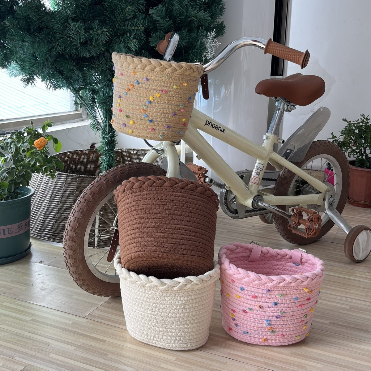 Pleciony koszyk rowerowy ze sznura z pomponami i skórzanymi paskami na kierownicę